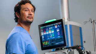 A healthcare professional stands in front of a PrisMax system