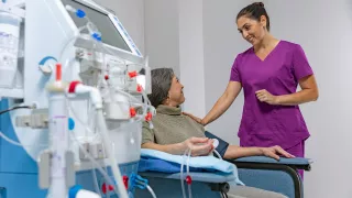 A healthcare professional is talking to her patient, who is receiving HD therapy