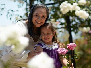 A lady and her granddaughter together in a rose garden