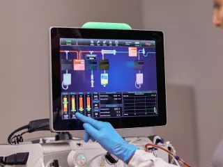 Healthcare professional interacts with the PrisMax system monitor