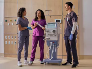 A Vantive employee demonstrates the AK 98 Dialysis Machine to two clinicians