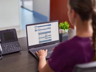 Healthcare professional views an online learning resource on a laptop at her desk