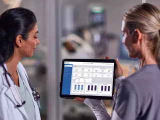 Two healthcare professionals look at TruVue data on a tablet device